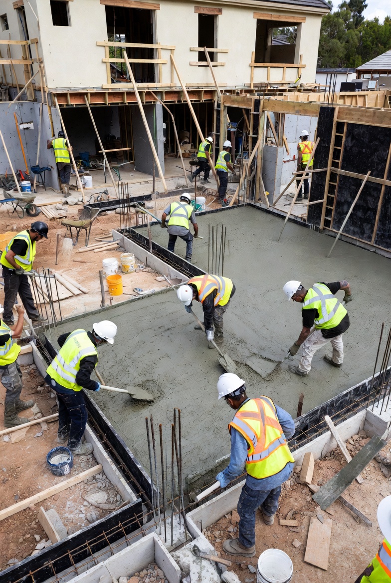 Concrete crew placing and leveling a residential foundation slab